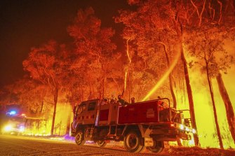 Firefighters work to get a blazing bushfire under control. 