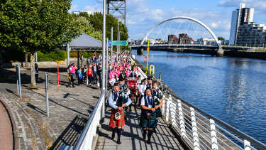 Delegates to the 2018 World Down Syndrome Congress in Glasgow are led along the Clyde river by the Dundee City Pipe Band. 