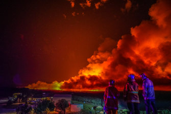 Firefighters watch on at blaze near Margaret River in Western Australia in December.