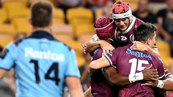 Jock Campbell is congratulated by Reds teammates after scoring a try against the Waratahs.