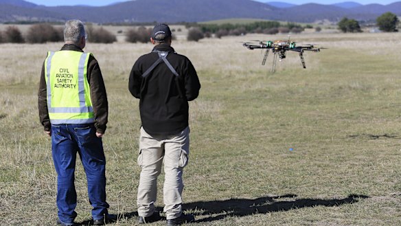 A CASA official watches a drone in flight.