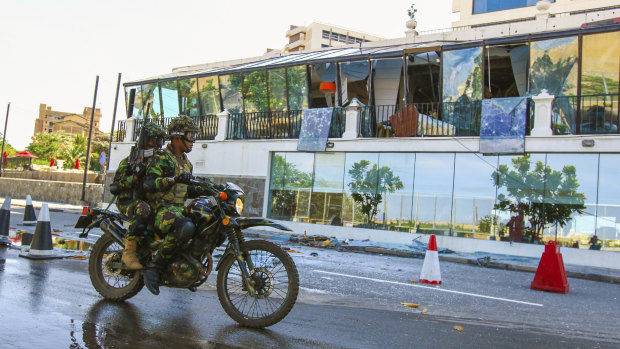 Sri Lankan soldiers ride past the bombed Kingsbury Hotel.