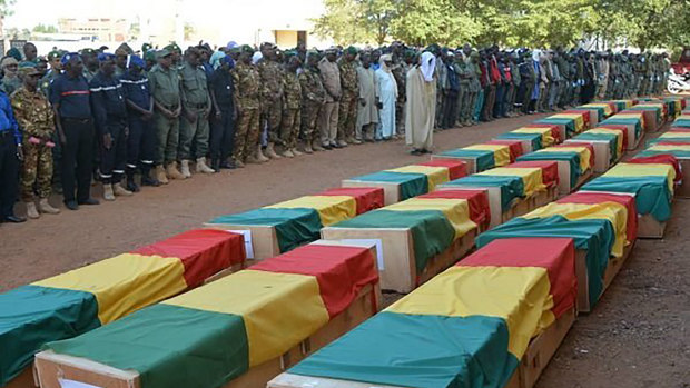 Showing coffins being honoured during a funeral ceremony in Mali.