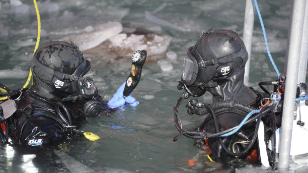 Coast Guard Petty Officer 2nd Class Garett Brada, a diver deployed aboard the US Coast Guard Cutter Polar Star, checks his dive gauges before a cold water ice dive off of McMurdo Station.