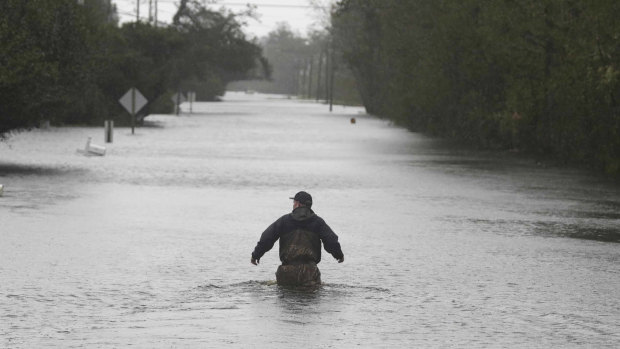 A member of the US Coast Guard walks down Mill Creek Road checking houses after tropical storm Florence hit Newport, North Carolina.