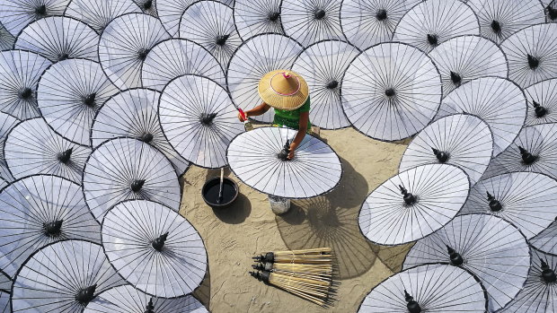 Aung Ya’s Among the White Umbrellas reminded the photographer of a girl sitting in a roost of butterflies, as she makes traditional umbrellas by hand in Myanmar.