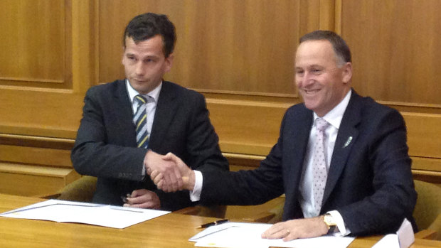 ACT MP David Seymour (left) signs a confidence and supply agreement with then-prime minister John Key.