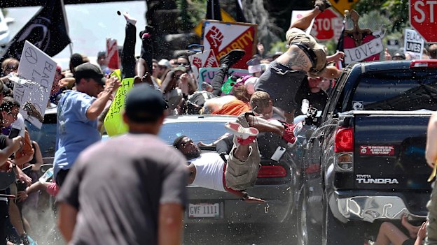 People fly into the air as a vehicle drives into a group of protesters demonstrating against a white nationalist rally in Charlottesville, Virginia.