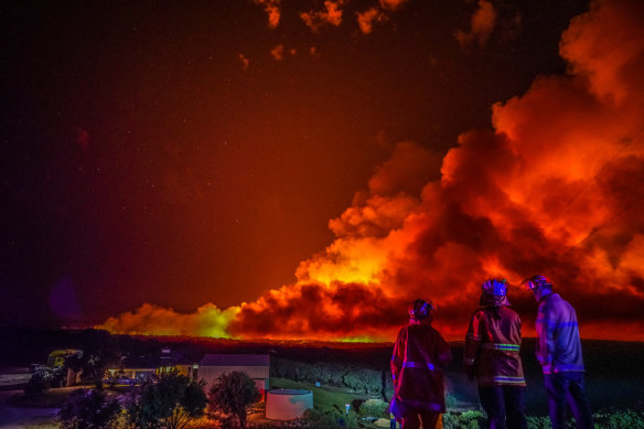 Firefighters watch on at blaze near Margaret River in Western Australia in December.