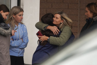 One parent hugs a child while others come to pick up students from the Meijer store in Oxford, Michigan, after an active shooting situation at Oxford High School.  .