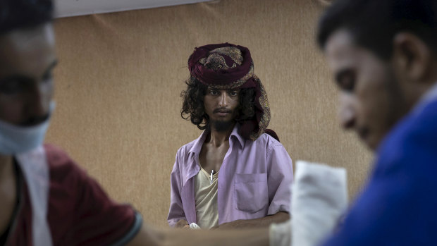 A hospital worker watches as doctors attempt to resuscitate Mohammed Kulaib, a Yemeni fighter with the Saudi Arabia-led Arab coalition, at a field hospital in Yemen's Al Durayhimi district.