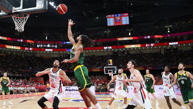 Patty Mills of Australia drives to the basket against Rudy Gobert of France.