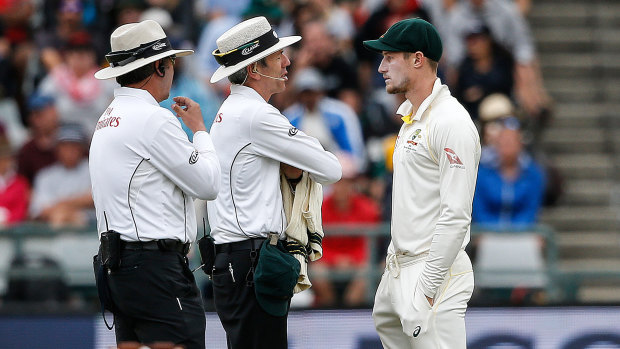 Caught: Umpires Richard Illingworth (left) and Nigel Llong confront Cameron Bancroft in Cape Town.