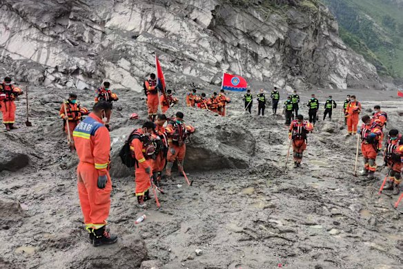 Rescuers observe a moment of silence for the victims of the mudslide near the Gyirong Port in south-western China’s Tibet Autonomous Region.