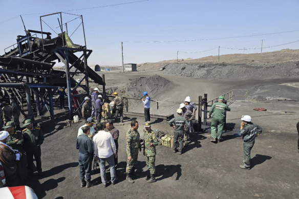 In this photo released by Iranian Red Crescent Society, miners and police officers gather around the site of a coal mine wher<em></em>e methane leak sparked an explosion.