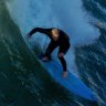 A surfer takes on a wave at Dee Why beach.