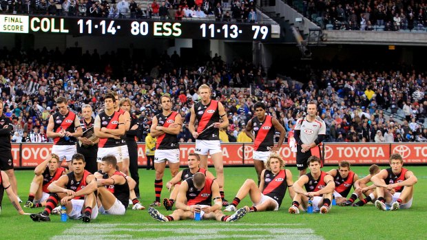 Bombed out: Shattered Essendon players ponder what might have been after going down by a point in an ANZAC Day classic.
