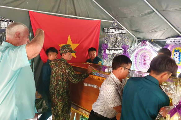 John Bryant salutes a casket holding the remains of North Vietnamese soldiers he fought at the Battle of Balmoral.