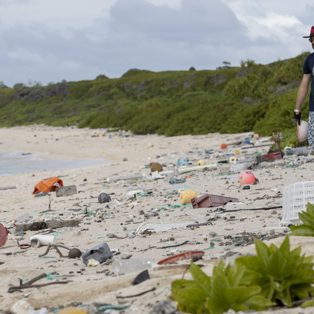 Recycling expert James Beard picks up rubbish along the beach.