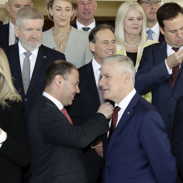 Members of the ministry put on Australian flag pins given to them by new Prime Minister Scott Morrison. 