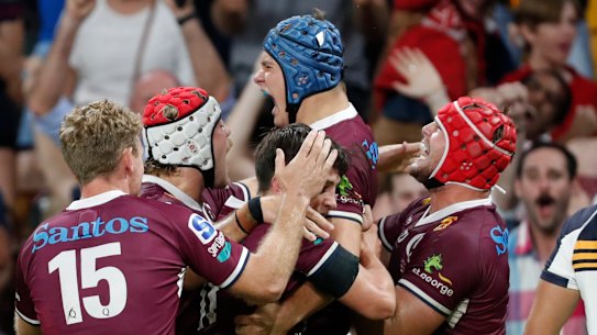 Josh Fluke of Reds celebrates with team mates after scoring a try against the Brumbies.
