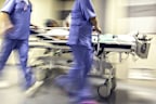 Doctors and nurses pulling hospital trolley, emergency room