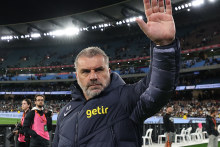Tottenham Hotspur coach Ange Postecoglou, right, and former Socceroos captain Mile Jedinak thanks fans at the MCG on Wednesday night.