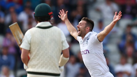 England’s Mark Wood celebrates after taking the wicket of Australia’s Travis Head on day three of the fourth Test at Old Trafford.