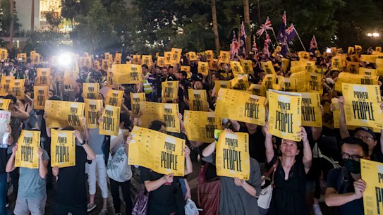 Demonstrators hold signs during the Stand with Hong Kong, Power To The People Rally at Chater Garden in Hong Kong, China.