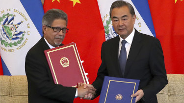 El Salvador's Foreign Minister Carlos Castaneda, left, and China's Foreign Minister Wang Yi shake hands at a signing ceremony to mark the establishment of diplomatic relations.