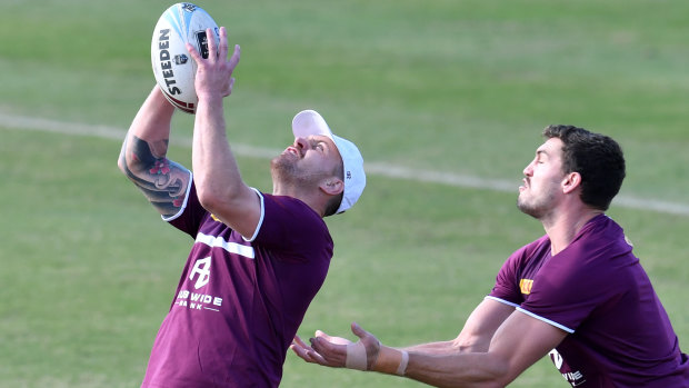 Familiar role: Cameron Munster defuses a bomb in front of Corey Oates at Queensland training.