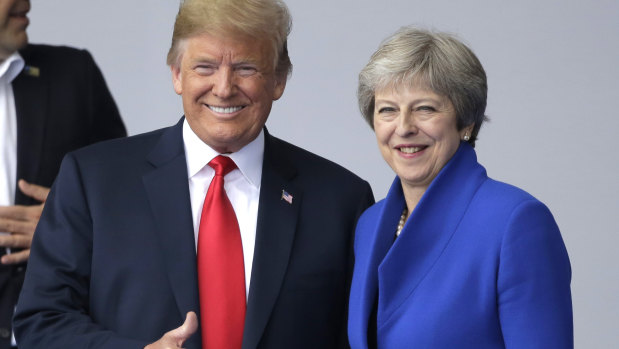 US President Donald Trump, left, talks to British Prime Minister Theresa May during a summit of heads of state and government at NATO headquarters in Brussels on Wednesday.