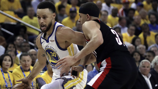 Steph Curry drives the ball against his brother Seth Curry.