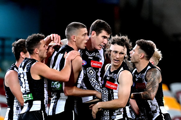 His teammates congratulate Cox for kicking a goal.