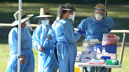 Health workers are seen as residents are tested for COVID-19 at a pop up testing clinic at Indooroopilly State High School, on July 31, 2021. 
