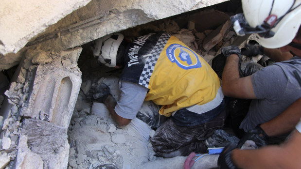 Rescuers remove a body from the rubble at the scene of the explosion in Sarmada, Idlib.