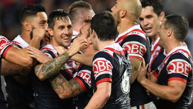 No hard feelings: Mitchell Pearce is mobbed by Roosters before he made his exit from the Bondi club.