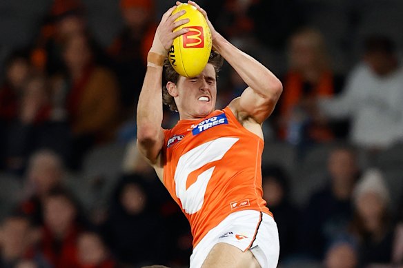 Aaron Cadman of the Giants marks the ball over Zach Merrett of the Bombers.