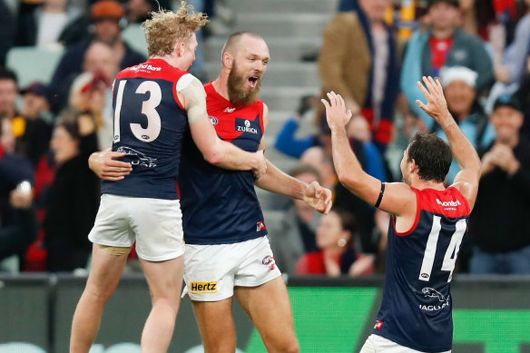 Clayton Oliver, left, Max Gawn and Michael Hibberd celebrate Melbourne’s win over Hawthorn on Sunday. 