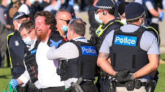 A man is taken away by police at the Shrine of Remembrance. 