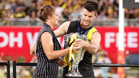 Ash Barty presents the 2021 AFL premiership cup to Trent Cotchin.