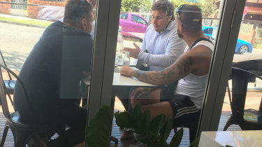 From left: George Alex (in black), Lindsay Kirschberg (obscured), Adam Cranston (in white shirt) and an unknown man (in singlet) at the February 2018 meeting in the Earlwood patisserie.