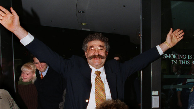 Bruno Grollo throws his arms into the air as he walks out of court after being acquitted of conspiracy charges.