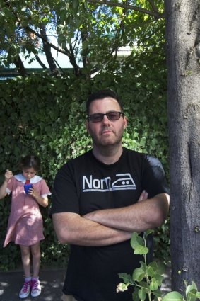 Domestic incident: Crime writer Adrian McKinty at his St Kilda home while his daughter Sophie eats a cup of Milo.