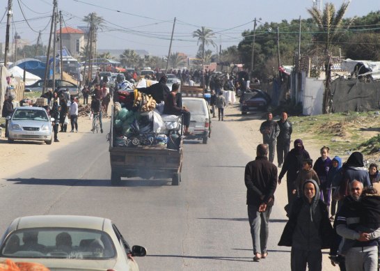 Displaced Palestinians move along the coastal road, ahead of Israeli military ground operations, west of Rafah and Khan Younis.