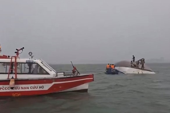 Image from a video showing people on a capsized tourist boat being rescued in Halong Bay, Vietnam, on Saturday
