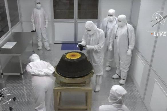 NASA, technicians in a clean room examine the sample return capsule from NASA’s Osiris-REx mission.