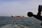 In this 2019 photo, a speedboat of Iran's Revolutionary Guard trains a weapon toward the British-flagged oil tanker Stena Impero, which was seized in the Strait of Hormuz by the Guard.