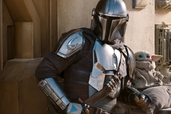 Pedro Pascal as the Mandalorian with Grogu.