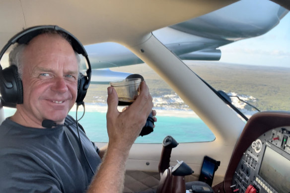 Michael Smith in the cockpit of his seaplane drinking coffee made on his on-board coffee machine.